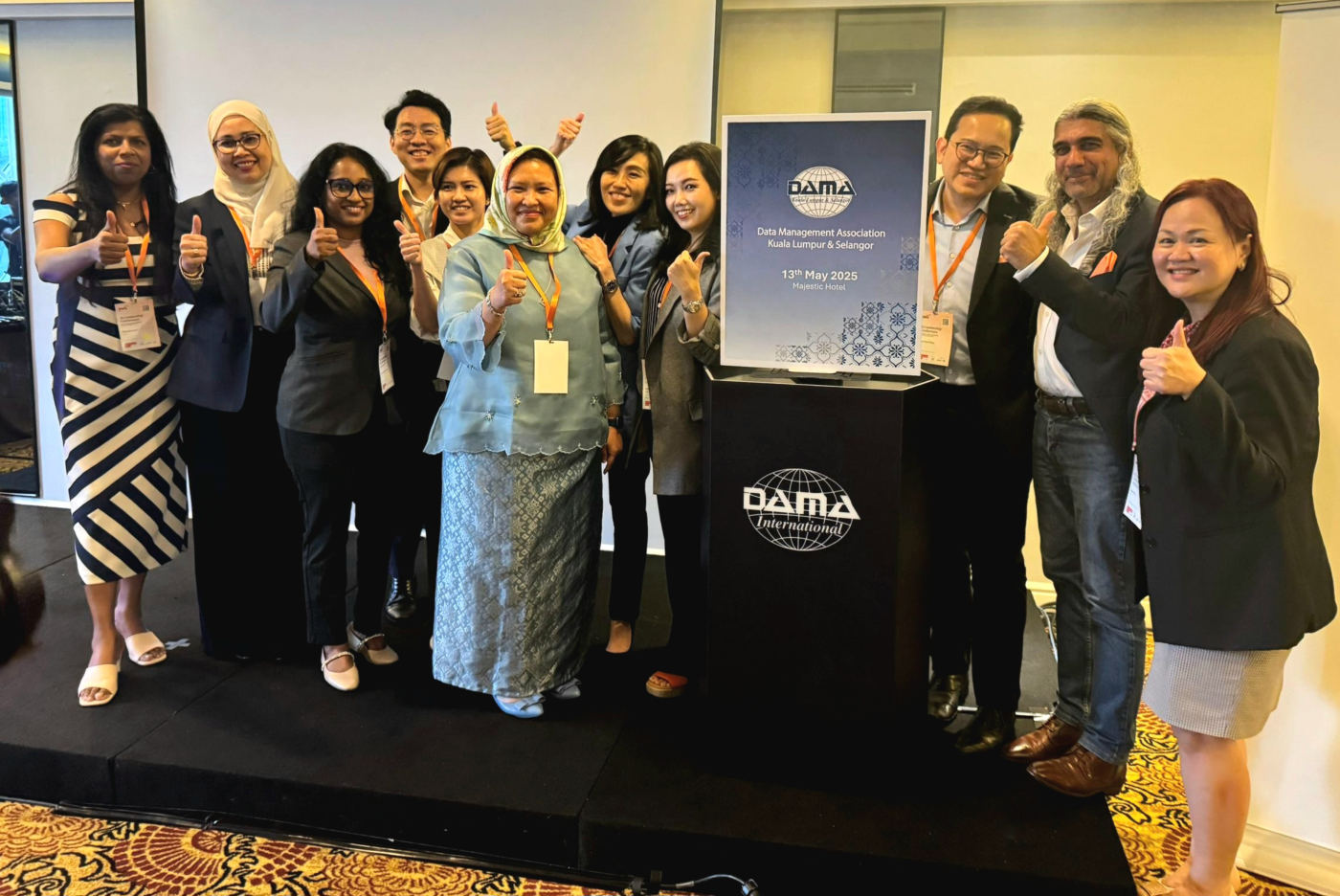 DAMA board and guests with the DAMA logo after the launch